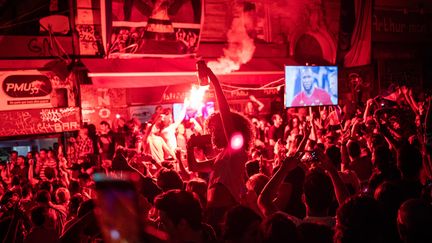 Les supporters ont allumé des feux de bengale&nbsp;devant ce bar de Marseille. (ROMAN PILIPEY / EPA)