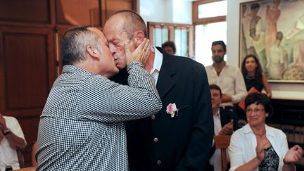 Jean-Michel Martin (&agrave; droite) et Guy Martineau-Sepel s'embrassent &agrave; la fin de leur c&eacute;r&eacute;monie de mariage, &agrave; Arcangues ((Pyr&eacute;n&eacute;es-Atlantiques), le 22 juillet 2013. (GAIZKA IROZ / AFP)