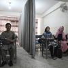 Des étudiants et des étudiantes afghanes&nbsp;séparés par un rideau, le 7 septembre 2021 dans une université privée de Kaboul (Afghanistan). (AAMIR QURESHI / AFP)