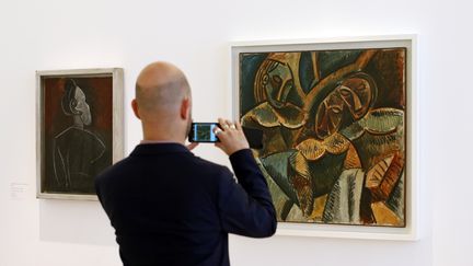 Un visiteur prend en photo "Trois figures sous un arbre", le 18 octobre 2014, &agrave; Paris, une&nbsp;peinture r&eacute;alis&eacute;e par Pablo Picasso. (BENOIT TESSIER / REUTERS)