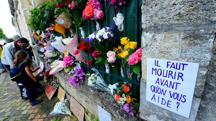 Fleurs et pancartes déposées devant le domicile de Sandra P. lors d'un hommage à la jeune femme à Bordeaux le 4 juillet 2021. (MEHDI FEDOUACH / AFP)