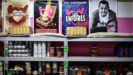 Un portrait de Coluche, une affiche des Enfoirés, des stocks d'aliments... Dans un centre des Restos du Cœur, le 23 novembre à Paris au moment du lancement de la 37e campagne de distribution de nourriture de l'association. (STEPHANE DE SAKUTIN / AFP)