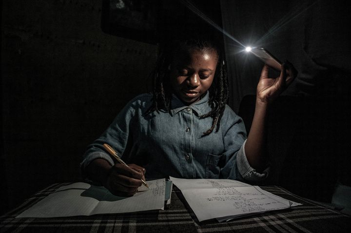 Goma, RDC, 27-28 avril 2020. Les écoles étant fermées pendant la période de confinement, et vu la régularité des coupures de courant dans la ville, ma petite sœur de 13 ans étudie à la maison en s’aidant de la torche d’un téléphone. (© ARLETTE BASHIZI)