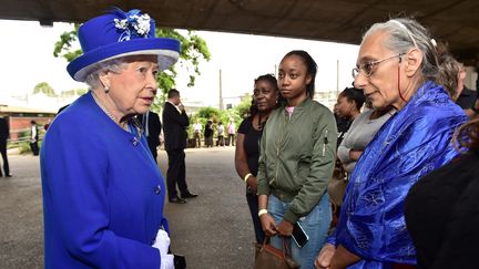 La reine Elisabeth II rencontre les familles touchée par l'incendie d'une tour de logements sociaux à Londres dans un centre sportif qui leur sert provisoirement d'abri, le 16 juin 2017 à Londres (Royaume-Uni). (DOMINIC LIPINSKI / POOL)