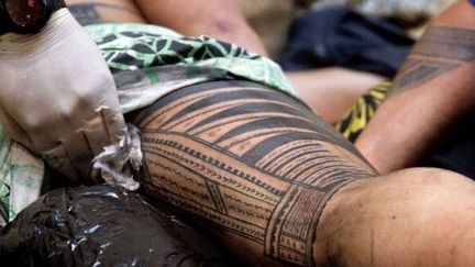 Le maître tatoueur Su'a Sulu'ape Paul fait une démonstration de tatouage à l'ancienne sur son client Ricky Masoe à Wellington (Nouvelle Zélande). (AFP PHOTO / MARTY MELVILLE)