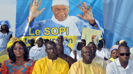 Des supporters d'Abdoulaye Wade sont assis sous un portrait du pr&eacute;sident, le 1er f&eacute;vrier 2012 &agrave;&nbsp;Ziguinchor (S&eacute;n&eacute;gal). (SEYLLOU / AFP)