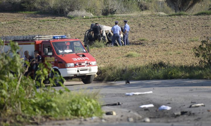 Des policiers s'affairent autour du véhicule où circulait Daphne Caruana Galizia, avant de perdre la vie dans une explosion, lundi 16 octobre dans le nord de Malte. (STR / AFP)