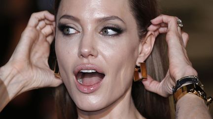 La com&eacute;dienne am&eacute;ricaine Angelina Jolie ajuste ses cheveux lors de la premi&egrave;re de "World War Z" &agrave; Tokyo (Japon), le 29 juillet 2013. (ISSEI KATO / REUTERS)