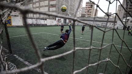 Arborant fièrement un maillot bleu frappé d'un ballon et d'une couronne surmontée d'une croix, de jeunes footballeurs coptes s'entraînent sous un soleil brûlant à Alexandrie, dans une académie destinée aux chrétiens victimes de discrimination en Egypte. La pelouse de l'académie «Je suis», en français dans le texte, est la seule où ils sont acceptés, soutiennent ces jeunes âgés de 15 à 27 ans. «Je jouais dans un club d'Alexandrie et il m'a été demandé de jouer sous un prénom musulman», raconte à l'AFP le fondateur de ce lieu inédit, Mina Bandari, qui porte un prénom très répandu chez les coptes. (MOHAMED EL-SHAHED / AFP)