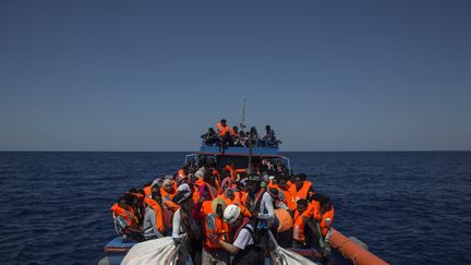 Des migrants secourus par les membres de&nbsp;l'Aquarius, le 2 août 2017. Le&nbsp;navire est géré par les ONG SOS&nbsp;Mediterranee et MSF. (ANGELOS TZORTZINIS / AFP)