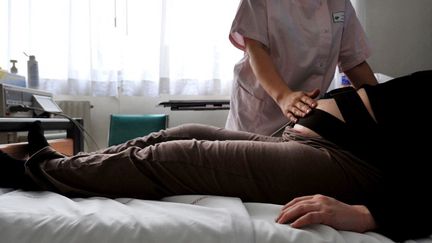 Une sage-femme rend visite à une femme enceinte à la maternité à Caen, le 17 février 2009. (MYCHELE DANIAU / AFP)