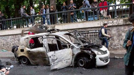 &nbsp; (La voiture de police s'était embrasée en quelques minutes à cause d'un fumigène © MaxPPP)