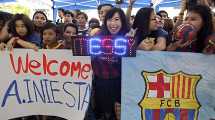 Des supporters thaïlandais du FC Barcelone à l'aéroport de Bangkok en août 2013 portent des panneaux pour accueillir Lionel Messi et Andres Inestia. (MAXPPP)