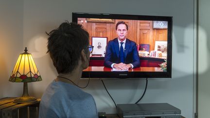 Une téléspectatrice néerlandaise devant l'allocution du Premier ministre Mark Rutte, le 15 décembre 2020 (SABINE JOOSTEN / ANP MAG)