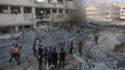 Des secouristes palestiniens éteignent un incendie dans un bâtiment endommagé à la suite d'un bombardement israélien qui a touché un complexe scolaire, au nord de Gaza, le 3 août 2024. (OMAR AL-QATTAA / AFP)