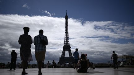 Des touristes admirent la tour Eiffel, le 3 août 2017 à Paris. (PHILIPPE LOPEZ / AFP)