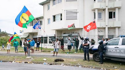 Des indépendantistes brandissent des drapeaux kanak, alors que l'association des parents du collège Tuband se rassemble pour rétablir le calme et rouvrir l'école à Nouméa (Nouvelle-Calédonie), le 11 juillet 2024. (DELPHINE MAYEUR / AFP)