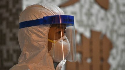 Un membre du personnel médical dans une résidence où deux personnes ont été testées positives au coronavirus, à Hong Kong, le 11 février 2020. (ANTHONY WALLACE / AFP)