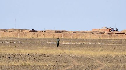 Une vue générale prise le 3 février 2017 dans la région d'Al-Mahbes montrant des soldats marocains (arrière-plan) gardant un poste d'observation le long de la barrière qui sépare le Sahara occidental contrôlé par le Polisario et le Maroc. (STRINGER/AFP)