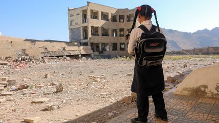 MARS. Une jeune Yéménite regarde ce qu'il reste de son école après un bombardement par la coalition arabe, le 16 mars 2017 à Taez (Yémen). (AHMAD AL-BASHA / AFP)