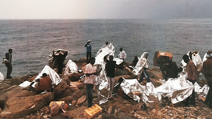 Migrants installés sur les rochers à la frontière franco-italienne. Photo issue de l'exposition "Europe, ouvre-toi !" des photographes et documentaristes Teresa Maffeis et Guy Ouillon présentée dans le cadre du festival photo Sept Off à Nice.
 (Culturebox - capture d&#039;écran)