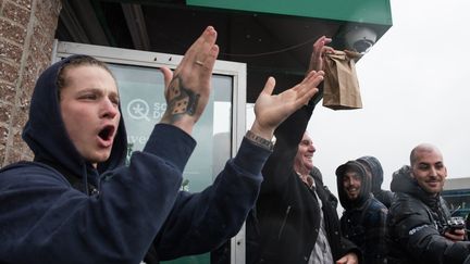 Des consommateurs se félicitent de la légalisation du cannabis devant une boutique à Québec (Canada), le 17 octobre 2018. (ALICE CHICHE / AFP)