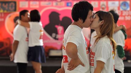 Difficile d'avoir l'air passionn&eacute; lorsque l'on participe au concours du plus long baiser du monde &agrave; Pattaya (Tha&iuml;lande), le 12 f&eacute;vrier 2013. (PORNCHAI KITTIWONGSAKUL / AFP)