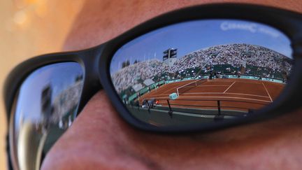 Roland-Garros se refl&egrave;te dans les lunettes d'un spectateur, le 27 mai 2012.&nbsp; (PATRICK KOVARIK / AFP)