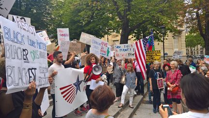 Une petite centaine de manifestants, des expatriés américains pour la plupart, ont exprimé leur mécontentement contre la politique de Donald Trump, jeudi 13 juillet 2017, place des Etats-Unis à Paris. (F. MAGNENOU / FRANCEINFO)