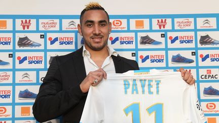 Dimitri Payet montre son maillot dans sa nouvelle équipe, l'OM, à Marseille, le 30 janvier 2017. (ANNE-CHRISTINE POUJOULAT / AFP)