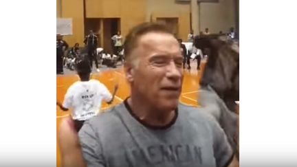 Capture d'écran d'une vidéo montrant Arnold Schwarzenegger recevoir par surprise un violent coup de pied dans le dos, lors d'un événement sportif, à Johannesbourg, en Afrique du Sud, samedi 18 mai 2019.&nbsp; (WORLD'S STRONGEST FAN / YOUTUBE)