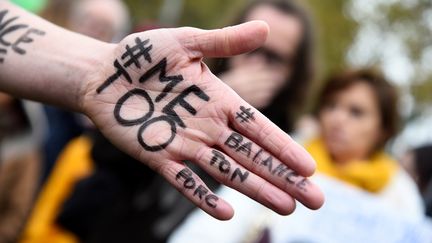 Les messages #metoo et #balancetonporc sur la main d'une manifestante, lors d'un rassemblement contre le harcèlement et les agressions sexuels, place de la République à Paris le 29 octobre 2017. (BERTRAND GUAY / AFP)