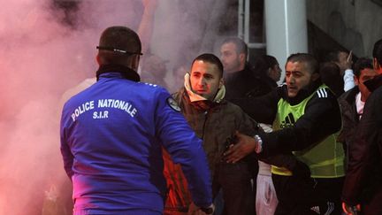 Un policier de la SIR intervient pour stopper un supporteur le 22 novembre 2012 au Vélodrome de Marseille. (BORIS HORVAT / AFP)