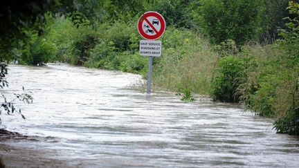 Une route ferm&eacute;e et submerg&eacute;e par l'eau pr&egrave;s de Lourdes (Hautes-Pyr&eacute;n&eacute;es), le 18 juin 2013. (PASCAL PAVANI / AFP)