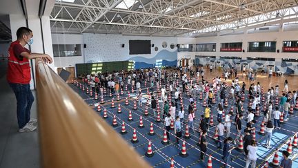 Des habitants font la queue pour un dépistage du Covid-19 dans un gymnase de Wuhan (Chine), jeudi 5 août 2021. (AFP)