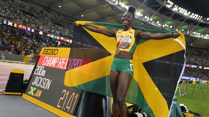 La Jamaïcaine Shericka Jackson, médaillée d'or sur le 200 m, pose devant le nouveau record du championnat du monde sur la distance (21''41), qu'elle a réalisé à Budapest, le 25 août 2023. (MATTHIAS SCHRADER / AP)