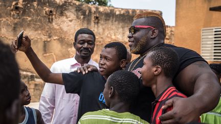 Aujourd'hui, lorsqu'il rentre de compétitions internationales à Bobo-Dioulasso, la 2e ville du Burkina Faso, Biby est accueilli en héros, des fans et curieux de tous âges se pressent pour lui réclamer un selfie ou toucher ses bras. Très attaché à son pays, Biby a décidé d'y retourner après ses études au Canada alors qu'il aurait pu rester en Amérique. (OLYMPIA DE MAISMONT / AFP)