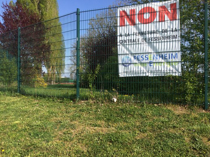 De nombreuses affiches condamnent le projet de fermeture de la centrale nucléaire, à Fessenheim (Haut-Rhin), le 6 avril 2017. (LICIA MEYSENQ / FRANCEINFO)