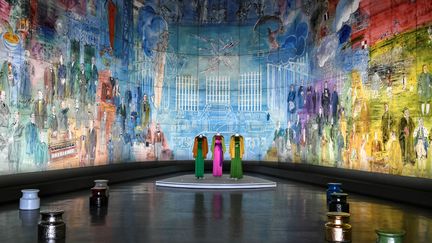 Les robes de Saint Laurent sur fond de l'oeuvre "La fée électrique" de Dufy, au Musée d'art moderne de Paris, le 24 janvier 2022.&nbsp; (STEPHANE DE SAKUTIN / AFP)