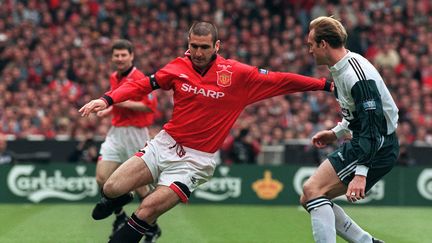 Le capitaine de Manchester United, le Français Eric Cantona dribble John Scales de Liverpoool en première mi-temps de la finale de la coupe d'Angleterre, le 11 mai 1996 sur le stade de Wembley à Londres (GERRY PENNY / AFP)