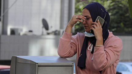 Une femme passe un appel à Beyrouth (Liban), le 15 août 2021, après l'explosion d'un camion-citerne dans la région du Akkar. (ANWAR AMRO / AFP)