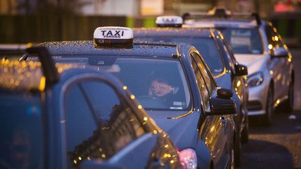 Des chauffeurs en grève s'apprêtent à passer la nuit dans leur taxi, porte Maillot, à Paris, le 28 janvier 2016. (GEOFFROY VAN DER HASSELT / AFP)