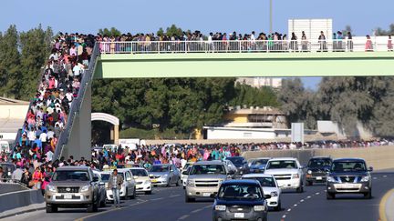 Des Chr&eacute;tiens traversent le pont pour se rendre &agrave; la cath&eacute;drale de Koweit Ciy (Koweit) pour la messe de No&euml;l. (YASSER AL-ZAYYAT / AFP)