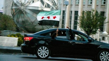 Des Syriens célèbrent l'effondrement du régime de Bachar al-Assad en Syrie, à Damas dimanche 8 décembre 2024. (MOHAMMED NAMMOOR / ANADOLU / VIA AFP)