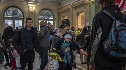 Des réfugiés ukrainiens font la queue pour obtenir des billets de train gratuits dans le hall de la gare principale de Przemysl, dans le sud-est de la Pologne, près de la frontière polono-ukrainienne, le 31 mars 2022 (ANGELOS TZORTZINIS / AFP)