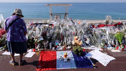 Une femme se tient devant le mémorial pour les victimes de l'attentat sur la promenade des Anglais, le 19 juillet 2016, à Nice (Alpes-Maritimes). (VALERY HACHE / AFP)