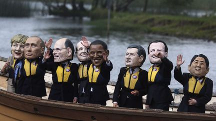 Des manifestants portant les "grosses t&ecirc;tes" des dirigeants du G8 manifestent contre la faim &agrave; l'occasion du sommet du G8 sur le lac d'Enniskillen (Irlande du Nord), le 17 juin 2013. (LEFTERIS PITARAKIS / AP / SIPA)