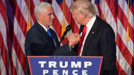 Mike Pence et Donald Trump se serrent la main, le 9 novembre 2016, à New York (Etats-Unis). (JIM WATSON / AFP)