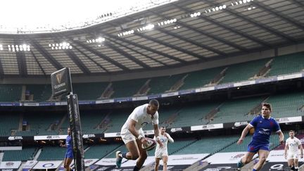 L'Anglais Watson aplatit sous le regard de Dupont, impuissant, lors de la défaite (23-20) du XV de France à Twickenham. (ADRIAN DENNIS / AFP)