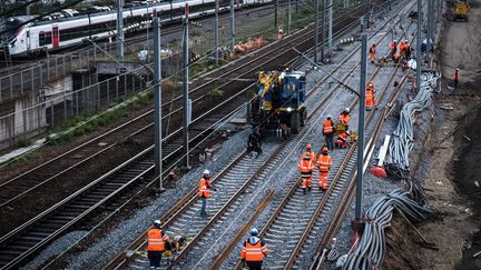 Des agents de la SNCF travaillant sur les voies près de la gare de l'Est à Paris, le 23 novembre 2019. (JOEL SAGET / AFP)